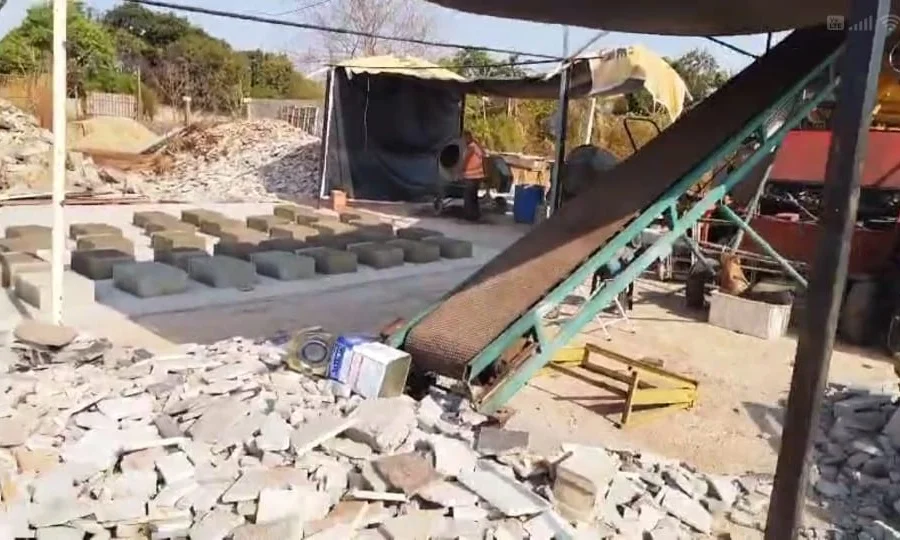 Linha de produção com esteira e blocos de concreto em secagem